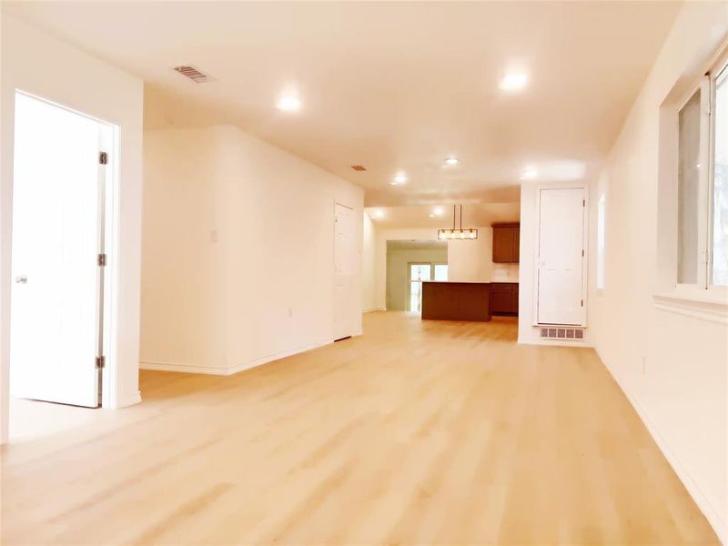 Spacious room featuring wood-finish flooring, recessed lighting, and multiple windows