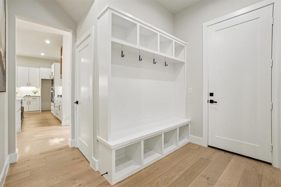 Mudroom with light wood finished floors and recessed lighting