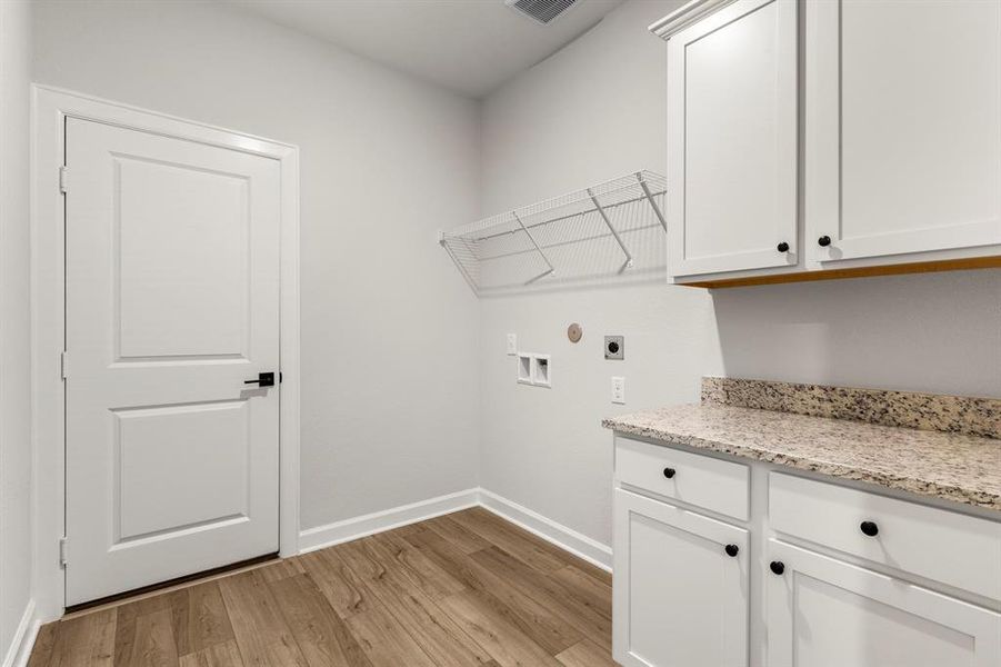 The utility room features storage cabinets and folding station.