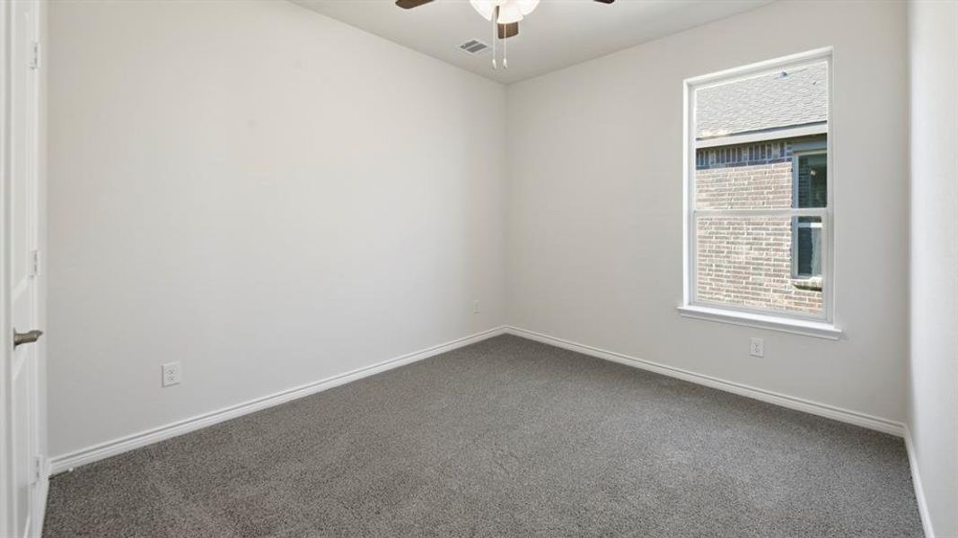 Spare room featuring carpet floors and a ceiling fan