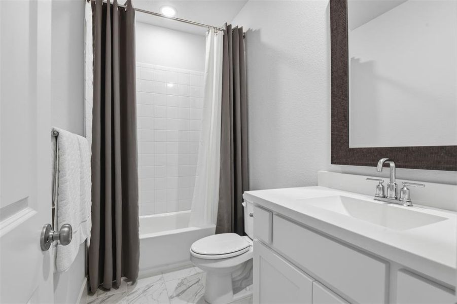 Bathroom featuring a white vanity with integrated sink, chrome faucet, and framed mirror Bathroom featuring a white vanity with integrated sink, chrome faucet, and framed mirror