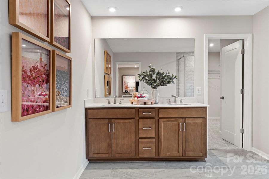 Dual Vanity with modern wood toned cabinetry and storage.