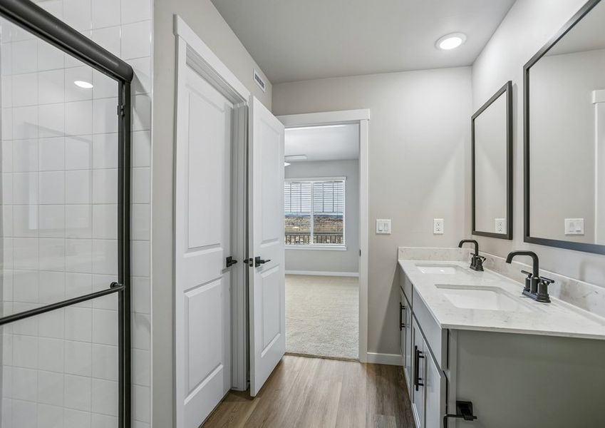The master bathroom has a dual sink vanity and step in shower