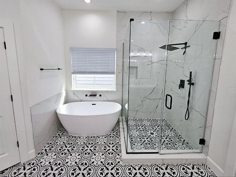 Primary bathroom, soaking tub, and the shower with the modern rain showerhead.