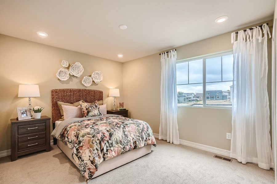 A bedroom with a large window.