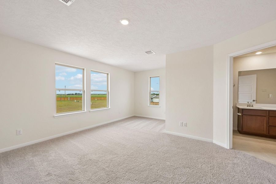 Relax and recharge in this stunning primary suite! Enjoy the comfort of plush carpeting, neutral-toned walls, high ceilings, recessed lighting, and large windows that fill the room with natural light.