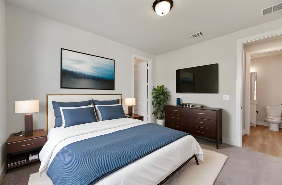 Bedroom featuring light colored carpet and ensuite bath