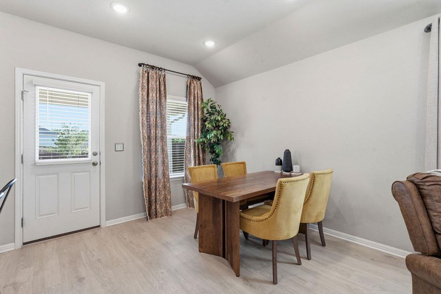 Dining space featuring light wood-type flooring, vaulted ceiling, and recessed lighting Dining space featuring light wood-type flooring, vaulted ceiling, and recessed lighting