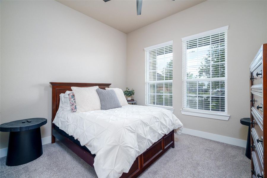 This charming bedroom features soft carpet flooring, a ceiling fan for added comfort, and a window with privacy blinds to let in natural light while maintaining your personal space. This charming bedroom features soft carpet flooring, a ceiling fan for added comfort, and a window with privacy blinds to let in natural light while maintaining your personal space.