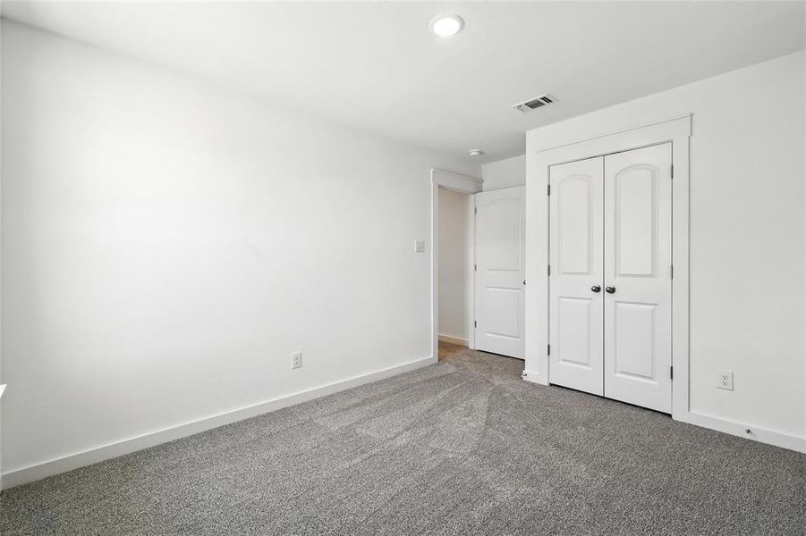 Unfurnished bedroom with carpet flooring and a closet Unfurnished bedroom with carpet flooring and a closet