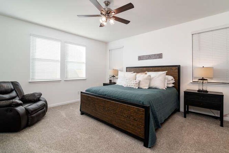 Carpeted bedroom featuring baseboards and a ceiling fan