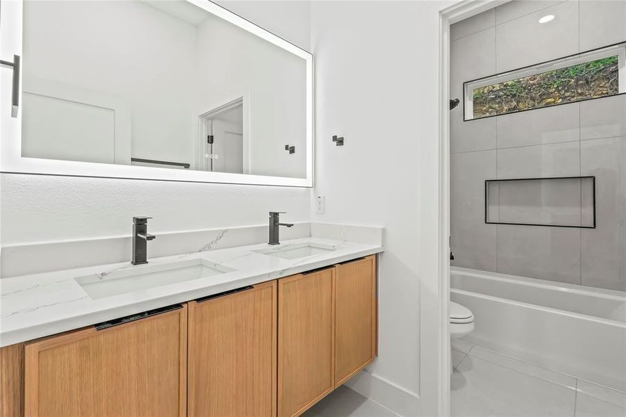 Full bath with double vanity, tile patterned flooring, and  shower combination