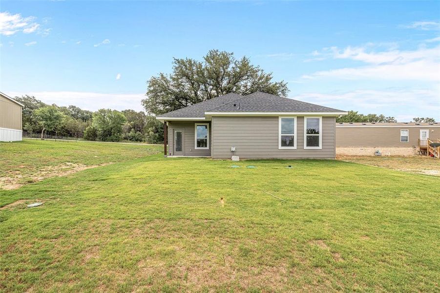 Rear view of property featuring a yard