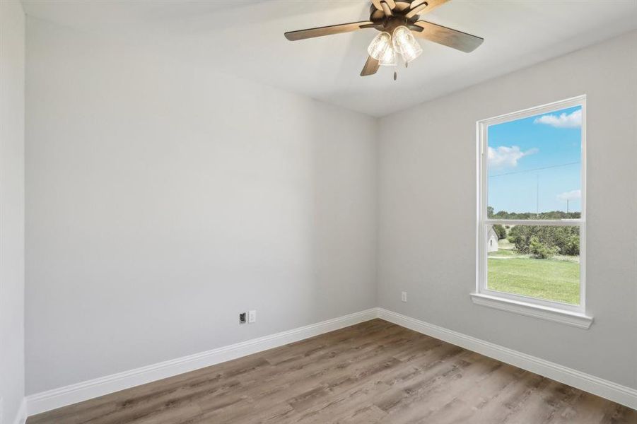 Unfurnished room featuring ceiling fan and hardwood / wood-style flooring