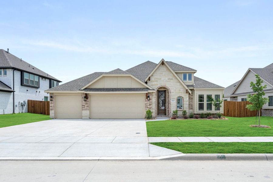 Single-story home with stone and brick exterior, three-car garage, arched entry, and manicured lawn Single-story home with stone and brick exterior, three-car garage, arched entry, and manicured lawn