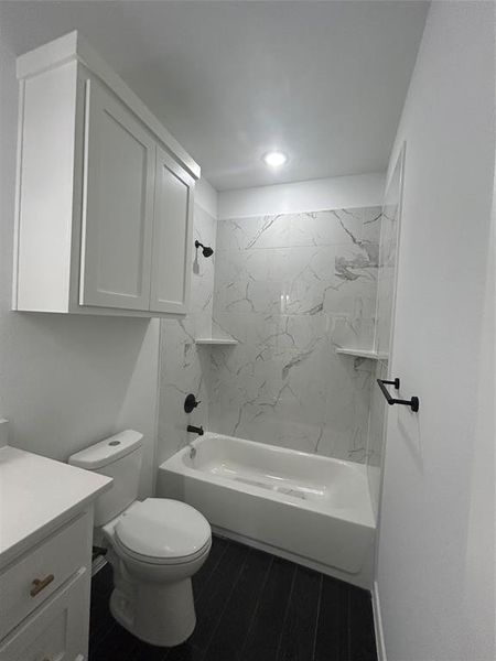 Full bathroom featuring tiled shower / bath, vanity, and toilet