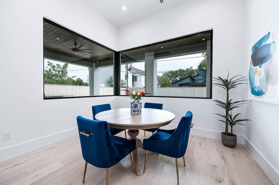 Breakfast area adjacent to the kitchen, featuring large-format windows that flood the space with natural light and backyard views.