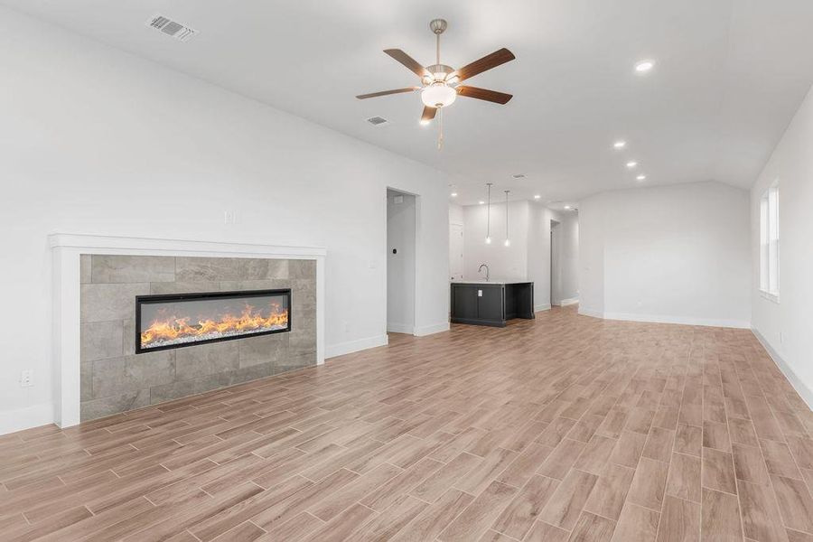 A spacious living area with warm wood-look tile flooring and a sleek fireplace. A spacious living area with warm wood-look tile flooring and a sleek fireplace.