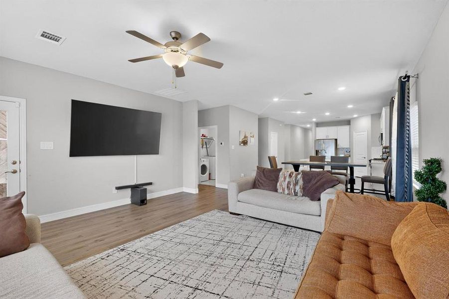 Living area featuring recessed lighting, ceiling fan, washer / clothes dryer, and light wood-style floors Living area featuring recessed lighting, ceiling fan, washer / clothes dryer, and light wood-style floors
