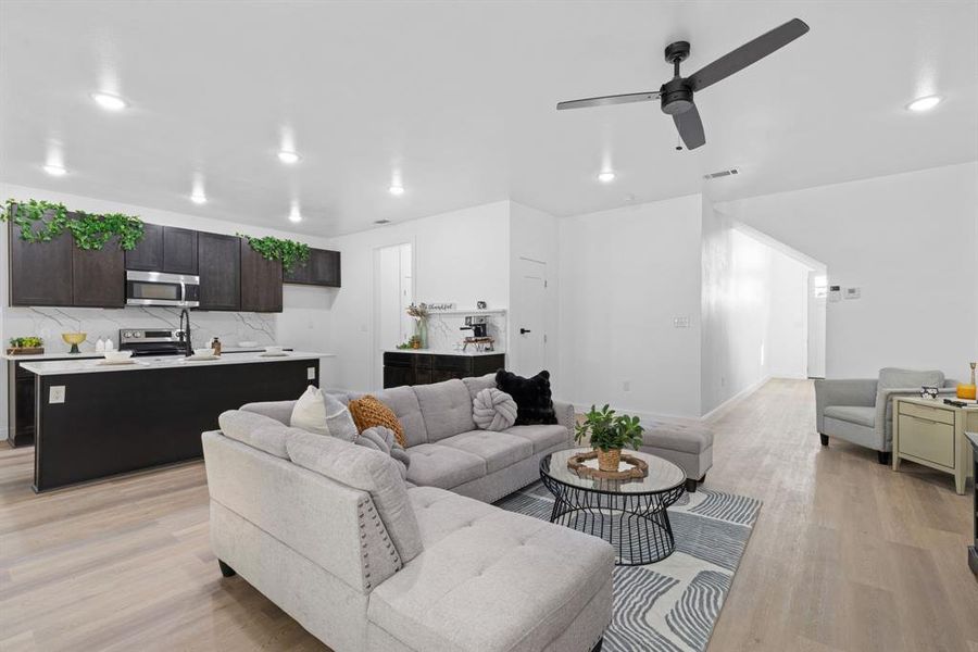 Living room with light hardwood / wood-style floors and ceiling fan