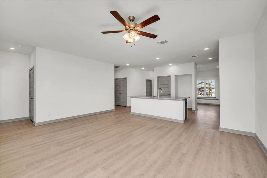Unfurnished living room featuring recessed lighting, light wood-type flooring, ceiling fan, and baseboard heating