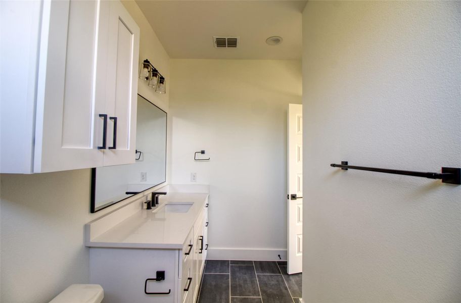 Bathroom featuring vanity and baseboards Bathroom featuring vanity and baseboards