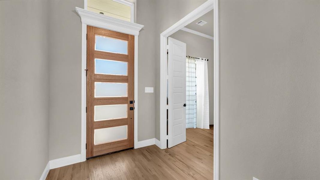 Beautiful entryway front door with crown molding allows for ample natural light.
