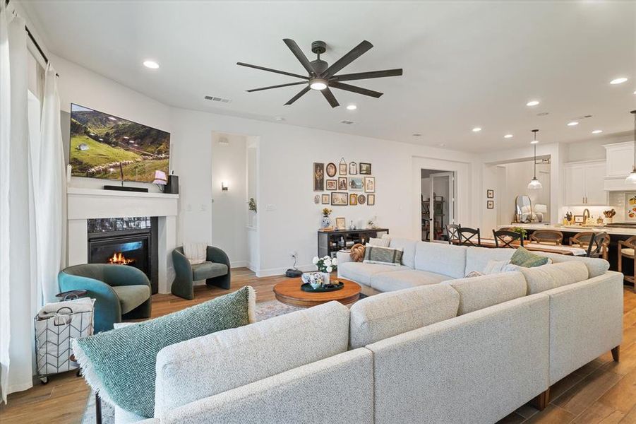 Living area with wood finished floors, a fireplace, recessed lighting, and ceiling fan Living area with wood finished floors, a fireplace, recessed lighting, and ceiling fan