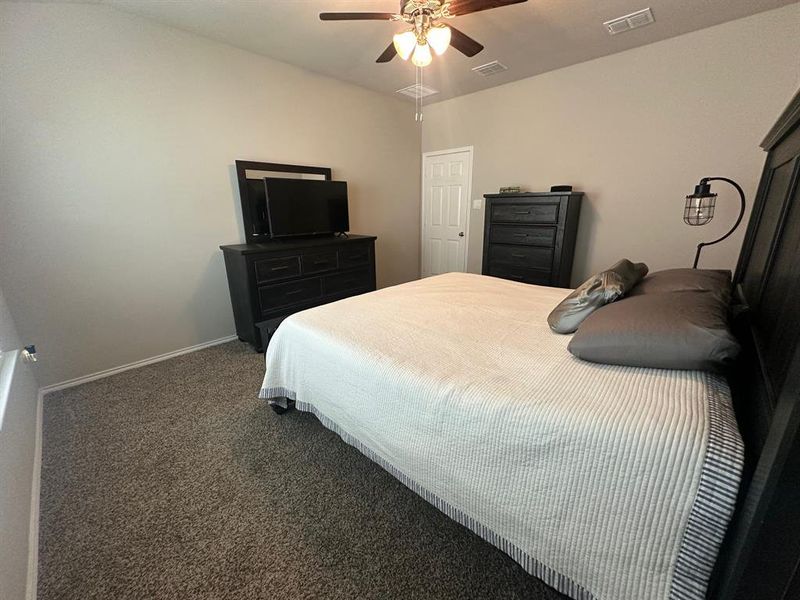 Bedroom with dark colored carpet and ceiling fan