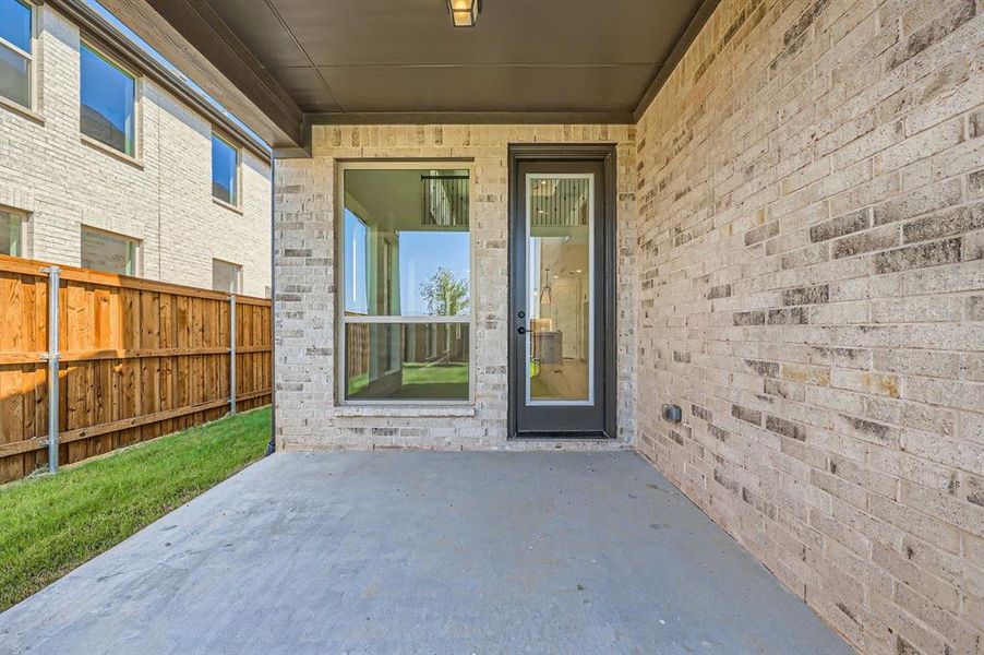 View of exterior entry with a patio area