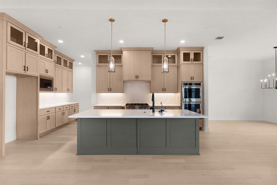 A well-appointed kitchen showcasing a spacious island with ample counter space and sophisticated modern finishes.