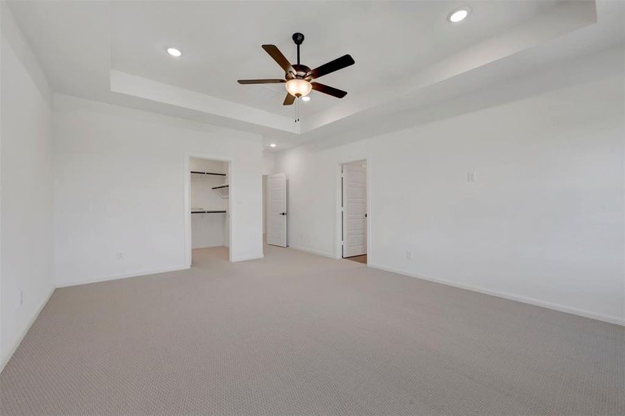 Spacious interior with neutral carpeting and a tray ceiling Spacious interior with neutral carpeting and a tray ceiling