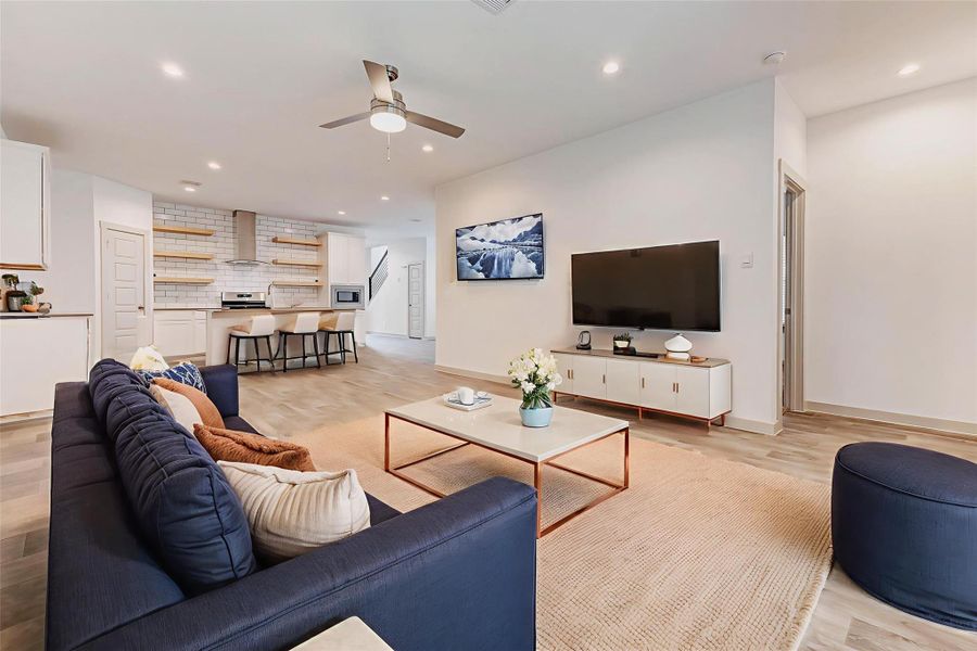 Open-concept living at its finest! The kitchen seamlessly transitions into a spacious living area, ideal for gatherings and everyday life. Wide plank wood-look flooring ties the whole space together, while recessed lighting and ceiling fan add comfort and efficiency. Open-concept living at its finest! The kitchen seamlessly transitions into a spacious living area, ideal for gatherings and everyday life. Wide plank wood-look flooring ties the whole space together, while recessed lighting and ceiling fan add comfort and efficiency.