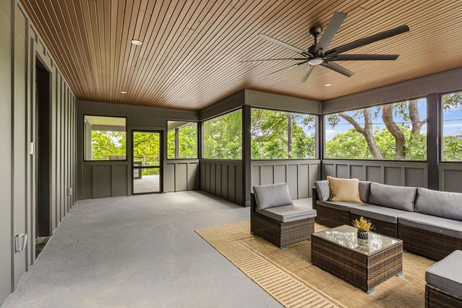 Spacious screened porch featuring a slatted wood-finish ceiling, recessed lighting, and a multi-blade ceiling fan