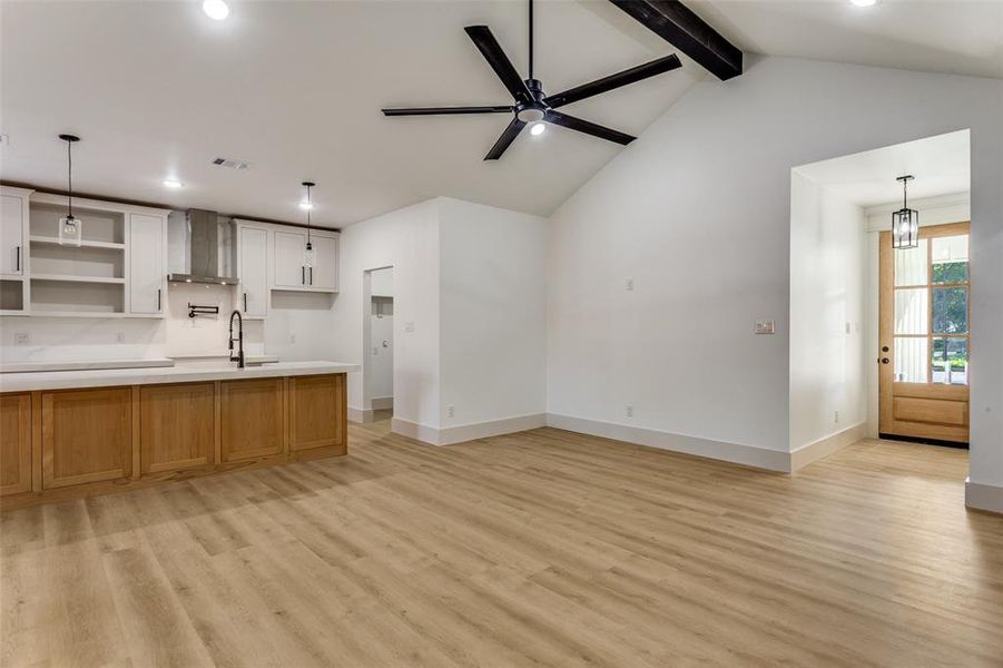 Kitchen with decorative light fixtures, light wood-style floors, light countertops, and recessed lighting Kitchen with decorative light fixtures, light wood-style floors, light countertops, and recessed lighting