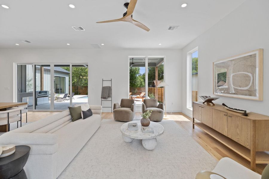 Living room with recessed lighting, light wood finished floors, and a ceiling fan Living room with recessed lighting, light wood finished floors, and a ceiling fan