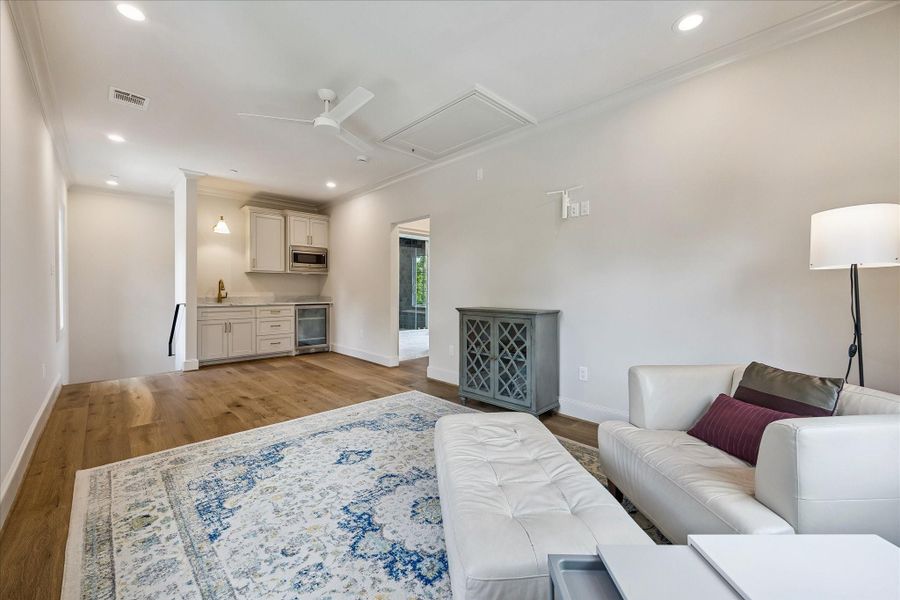 Fabulous private mother-in-law/guest suite is complete with a kitchenette featuring custom cabinetry, stone slab countertops, sink, microwave, and beverage refrigerator. Ideal for guests or family, this suite offers both comfort and independence with thoughtful, high-end finishes throughout. We love the hardwoods, recessed lighting and ceiling fan.