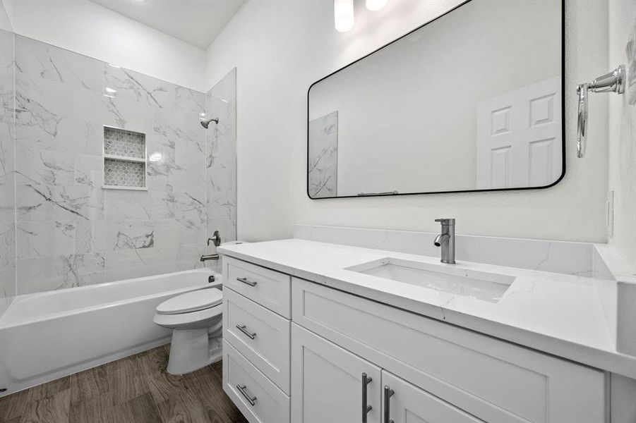 White vanity with a solid surface countertop, an integrated rectangular sink, and a black-framed mirror White vanity with a solid surface countertop, an integrated rectangular sink, and a black-framed mirror