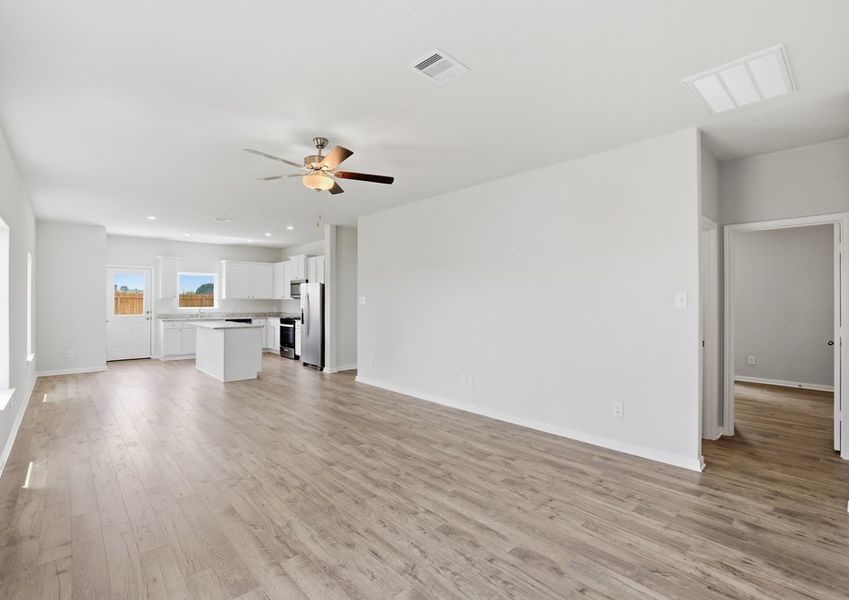 Living room featuring a ceiling fan, wood-look flooring, and an open-concept layout.