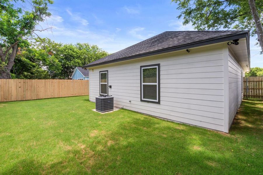 Rear view of house with a shingled roof and a fenced backyard Rear view of house with a shingled roof and a fenced backyard