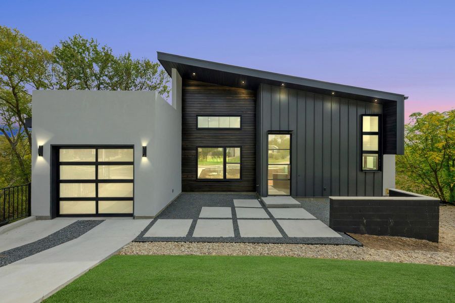 View of front of house with an attached garage, a patio area, and board and batten siding View of front of house with an attached garage, a patio area, and board and batten siding