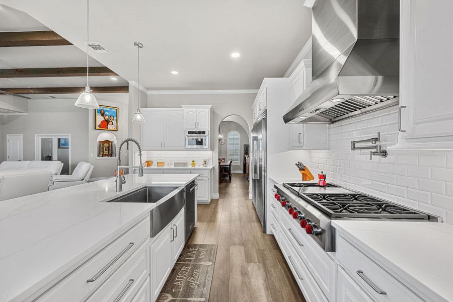 Culinary delights await in this bright kitchen with a spacious island, premium appliances, and warm wood flooring. Culinary delights await in this bright kitchen with a spacious island, premium appliances, and warm wood flooring.