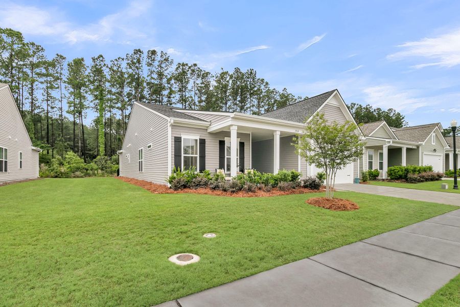 Front exterior of a new home in K. Hovnanian's® Four Seasons at Lakes of Cane Bay, Summerville, SC, highlighting curb appeal (Image 22).