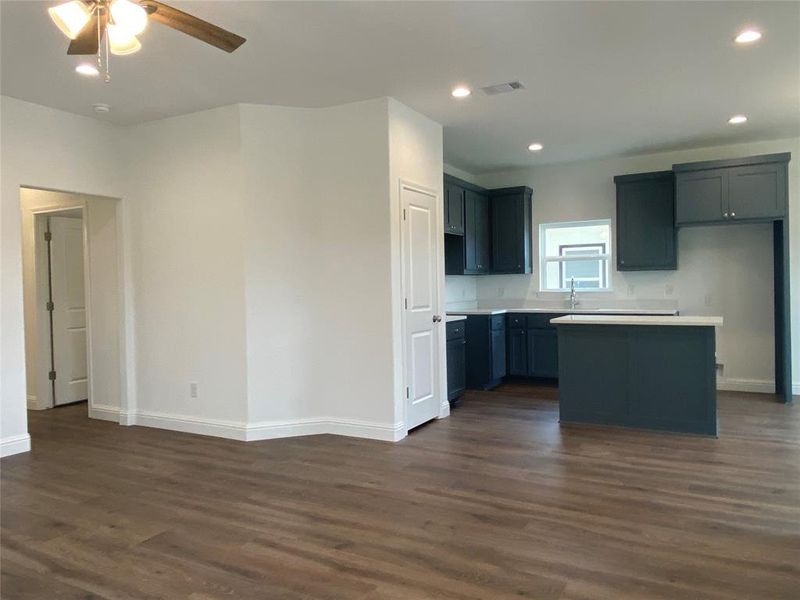Kitchen featuring dark wood finished floors, light countertops, recessed lighting, a kitchen island, and ceiling fan Kitchen featuring dark wood finished floors, light countertops, recessed lighting, a kitchen island, and ceiling fan