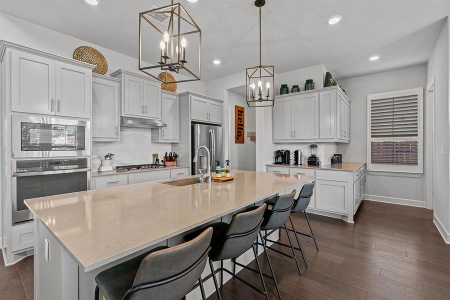 The huge center island/breakfast bar combo overlooks the kitchen and provides an ample amount of extra seating.