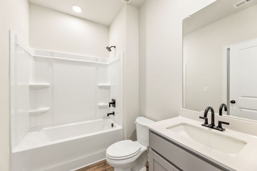 A bathroom with a tub sink and toilet. A bathroom with a tub sink and toilet.