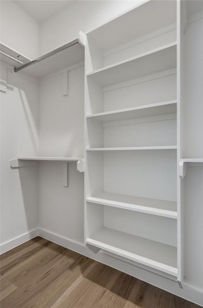 Functional custom closet system with hanging space and ample shelving ensures organization.