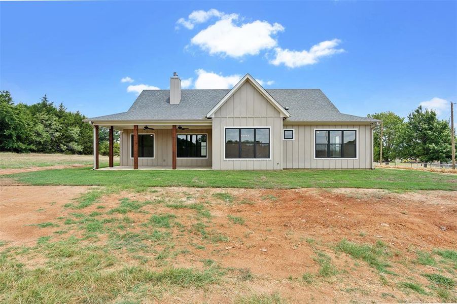 Rear view of house featuring a yard