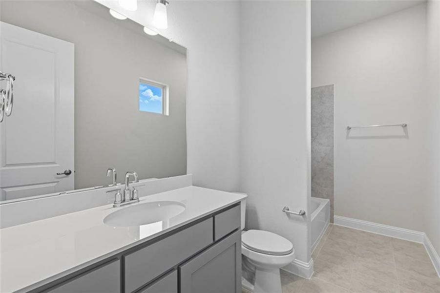 Bathroom featuring vanity, light tile patterned floors, and bathtub / shower combination