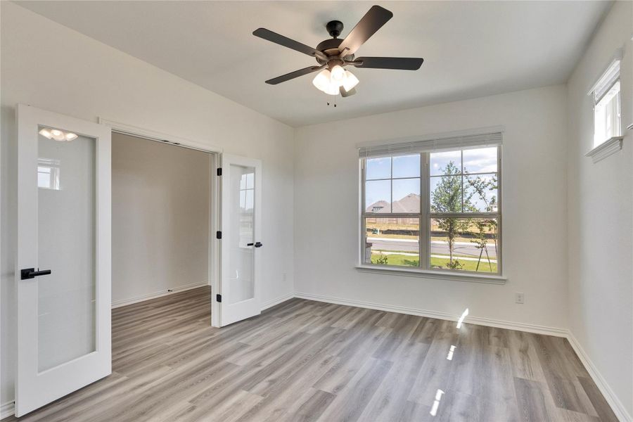 Unfurnished bedroom with light wood-style floors, ceiling fan, and french doors